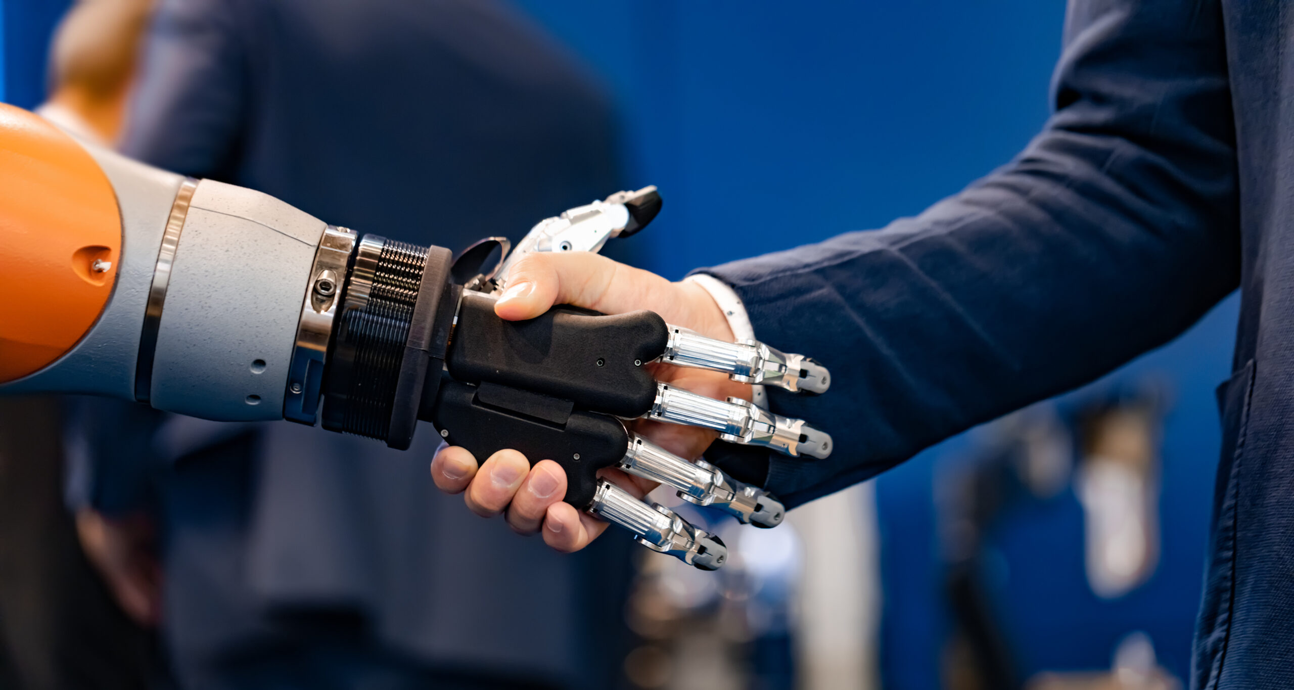 Hand of a businessman shaking hands with a Android robot. The concept of human interaction with artificial intelligence.